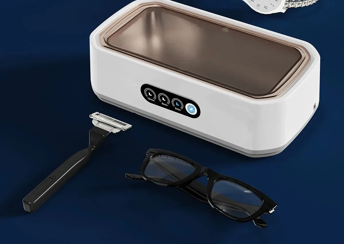 Nettoyeur à ultrasons Sonéclat ouvert, une paire de lunettes et une bague immergées dans la cuve inox